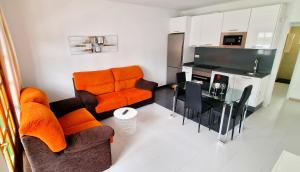 a living room with an orange couch and a table at Apartamento de la Playa II in Tías