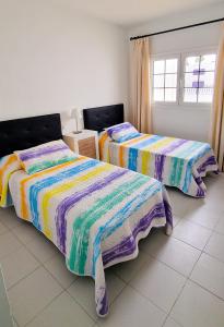 a bedroom with two beds and a window at Apartamento de la Playa II in Tías