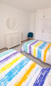 a bedroom with two beds and a chair at Apartamento de la Playa II in Tías +1 photo