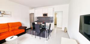a living room with an orange couch and a table at Apartamento de la Playa II in Tías