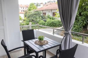 a table and chairs on a balcony with a window at Olivia Apartment 2 in Pefkohori
