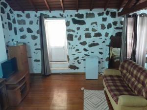ein Wohnzimmer mit einer kugelgemusterten Wand in der Unterkunft Casa da Fazenda in Santa Cruz das Flores