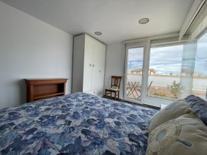 Un dormitorio con una cama y una ventana grande. en Ático con vista al Mar Menor, en Santiago de la Ribera