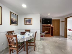 Un comedor con mesa y sillas y un televisor. en Ático con vista al Mar Menor, en Santiago de la Ribera
