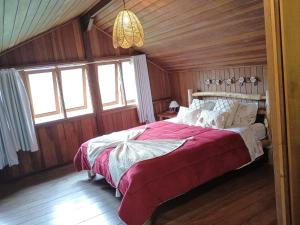 1 dormitorio con 1 cama grande en una habitación con paredes de madera en CHALÉ Além do Horizonte en Bocaina de Minas