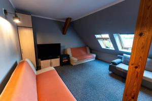 a room with a bed and a couch and a tv at Domek nad jeziorem Dobskim - Fuleda 5 in Fuleda