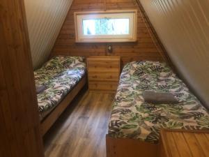 a small room with two beds and a window at Domek pod świerkami 2 in Skorzęcin