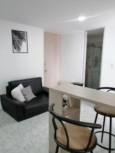 a living room with a black couch and a table at Apartamento con la mejor ubicación y descanso in Armenia