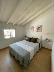 een witte slaapkamer met 2 bedden en een raam bij Casa del Portillete in Montejaque