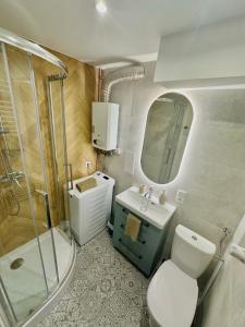 a bathroom with a toilet and a sink and a shower at Apartament Zielone Serce Miasta in Mrągowo