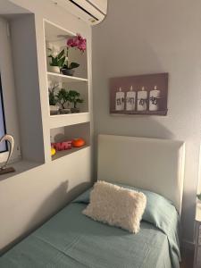 een slaapkamer met een bed en een plank met planten bij Sweet home in Póros +29 foto's