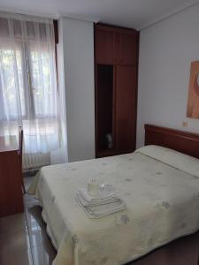 ein Schlafzimmer mit einem Bett mit einer Kerze darauf in der Unterkunft Pensión Rada in Solares