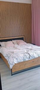 een bed met een houten frame in een slaapkamer bij Appartement Küstenperle in Świnoujście