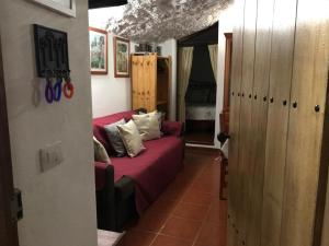 una sala de estar con un sofá rojo en una habitación en Finca Las Polinarias Casa Cueva en Fasnia en Santa Cruz de Tenerife