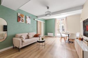 een woonkamer met een bank en een tafel bij Appartement 2P Confort Hyper Centre & 100m de la plage in Dieppe