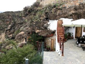 a white building with a staircase next to a mountain at Finca Las Polinarias Casa Cueva en Fasnia in Santa Cruz de Tenerife