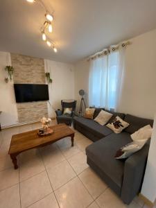 a living room with a couch and a table at Maison avec jardin Orléans métropole in Fleury-les-Aubrais