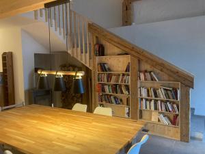 una sala da pranzo con tavolo e libreria con libri di Le Fort a Gimel