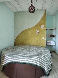 ein Schlafzimmer mit einem Bett und einer Wand mit Tellern darauf in der Unterkunft Casa Rustica in Baía da Traição