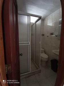 GairaにあるApartamento Edificio Maracaiboのトイレとガラスのシャワー付きのバスルーム