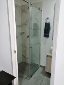 y baño con ducha y puerta de cristal. en Apartamento con la mejor ubicación y descanso, en Armenia