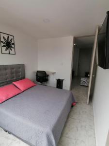 1 dormitorio con 1 cama y TV de pantalla plana en Apartamento con la mejor ubicación y descanso, en Armenia