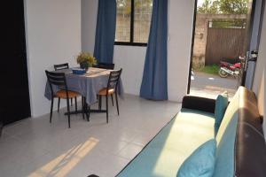 a living room with a table and chairs and a couch at Mini depa Cocoloft- a solo 1 cuadra de la playa in Chachalacas