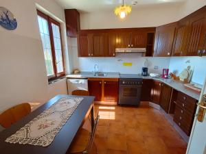 a kitchen with wooden cabinets and a table with chairs at Casa Atana - a Tuscan gem in Licciana Nardi +8 photos
