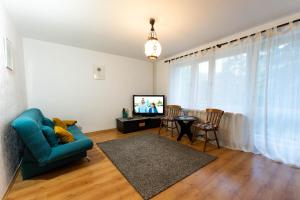 salon z niebieską kanapą i telewizorem w obiekcie Giżycko- duże mieszkanie w mieście Giżycko