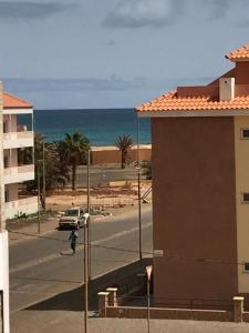 a view of a street with a building and the ocean at Blue eagle Guesthouse in Santa Maria