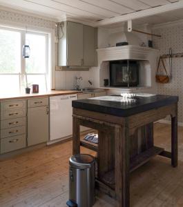 a kitchen with a island in the middle of it at Lovely cabin with a beautiful view over Byske river in Byske