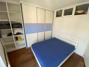 een kleine kamer met een blauw bed en planken bij CIMI Apartment in Belgrado