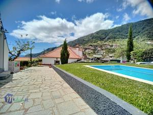 a backyard with a swimming pool and a house at Passion Villa in Machico