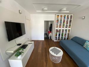 een woonkamer met een blauwe bank en een tv bij CIMI Apartment in Belgrado