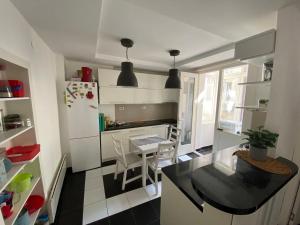een keuken met een tafel en een witte koelkast bij CIMI Apartment in Belgrado