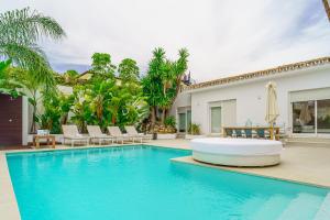 uma piscina com cadeiras e uma casa em Villa in PUERTO BANUS em Marbella
