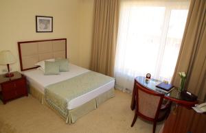 Un pat sau paturi într-o cameră la Park Hotel Bishkek