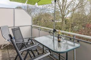 d'une table et de chaises sur un balcon avec un parasol dans l'établissement 50178..., à Harlesiel