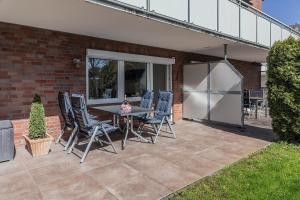 eine Terrasse mit Tisch und Stühlen und einem Kühlschrank in der Unterkunft 50177... in Harlesiel