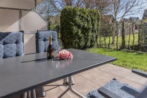 a table with a bottle of wine and flowers on it at 50177... in Harlesiel