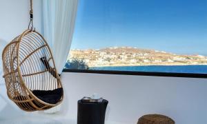 ein Hängesessel aus Rattan vor einem Fenster in der Unterkunft Mbc Psarou Black Retreat 11 Bedrooms Mykonos in Psarrou