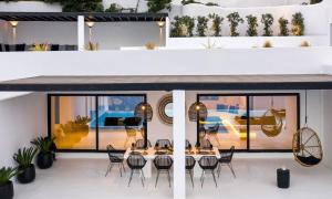 ein Raum mit einem Tisch und Stühlen in einem Gebäude in der Unterkunft Mbc Psarou Black Retreat 11 Bedrooms Mykonos in Psarrou