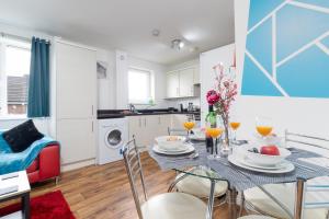 a kitchen and dining room with a table and chairs at 2-BR Executive En-Suite Apartment by MBiZ in Coventry