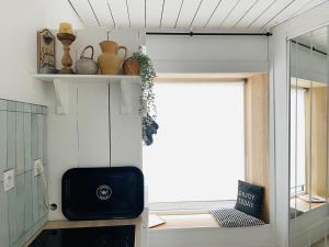 a small kitchen with a window in a tiny house at White and Sea Lodge in Locquirec