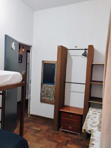 - une chambre avec un lit, une commode et un miroir dans l'établissement Pousada Seu Souza, à Belo Horizonte