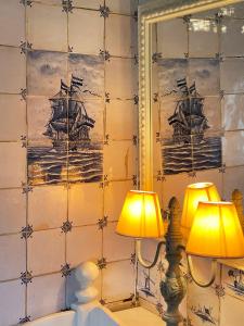 dos lámparas en una pared con una pintura de un barco en Friesenhaus Amrum Friesenhaushälfte *Hommelkasche* en Süddorf