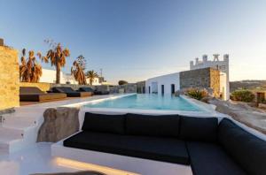 une villa avec une piscine et un canapé dans l'établissement Exquisite Mykonos Villa Villa Apocryphos 6 Bedrooms Unique Aegean Sea View, à Glastros