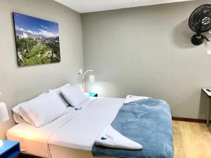 a bedroom with a large white bed in a room at Poblado Park Guest House in Medellín