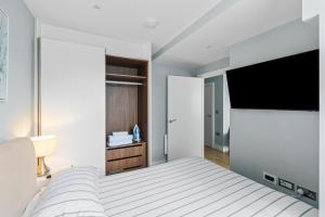 Luxurious One Bedroom Apartment in Bond Street في تشيلمسفورد: غرفة نوم بسرير وتلفزيون بشاشة مسطحة