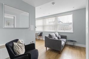 a living room with a couch and a chair at Luxurious One Bedroom Apartment in Bond Street in Chelmsford